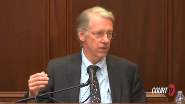 Blonde, middle aged man in a suit testifies.