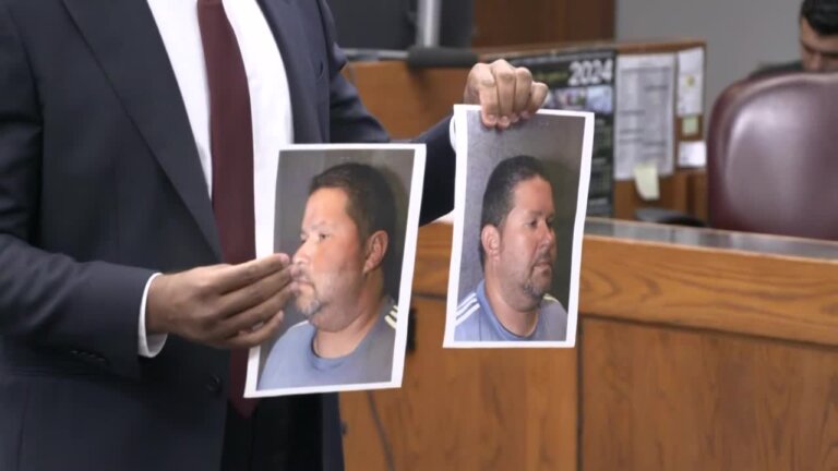 man holds pictures of mugshots