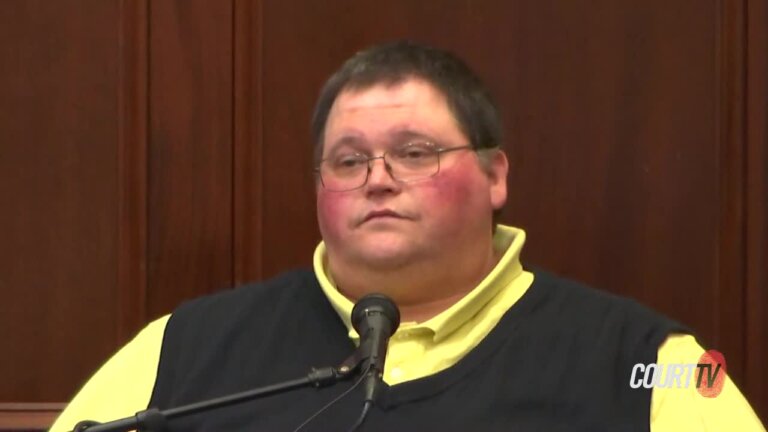 man in yellow shirt and black vest testifies in court