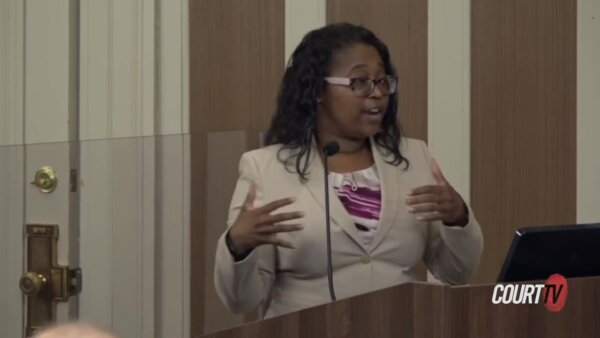 Young female prosecutor speaks at a podium