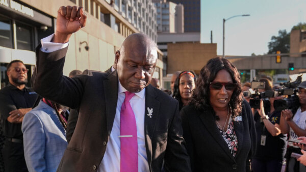 Ben Crump pumps fist walking next to RowVaughn Wells