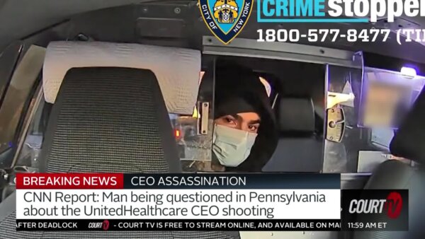 suspect with mask on in back of car