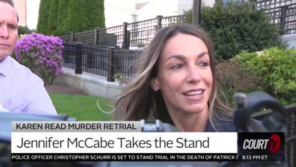 woman exits a courthouse and is being interviewed