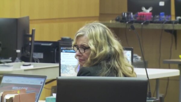 woman wears glasses in court and looks at the camera