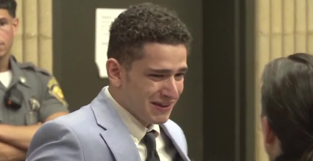 young man in a suit sobs like a baby in court