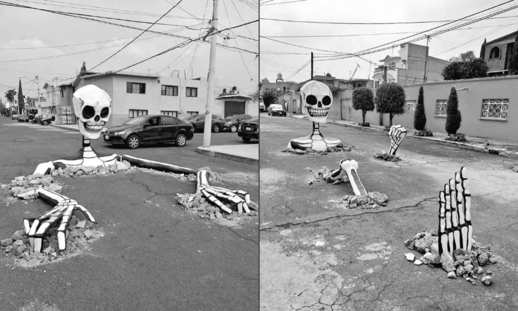 El colectivo 'Indios Yaocalli' creó estas calaveras gigantes que simulan salir de las calles, la instalación forma parte de un festival de Día de Muertos.