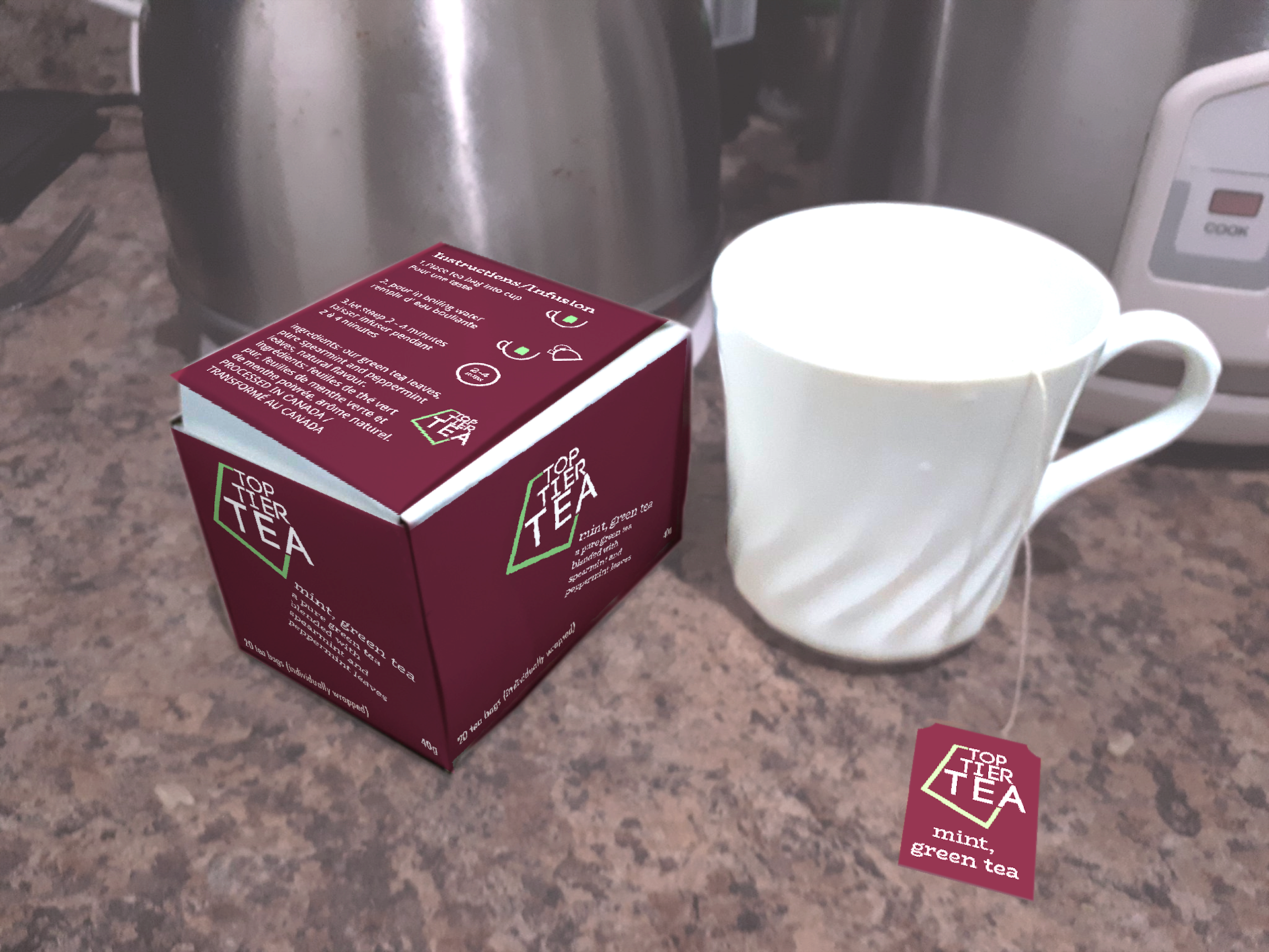 picture of a counter top with a kettle and rice cooker in the background and a maroon, white and green box and white mug in the foreground
