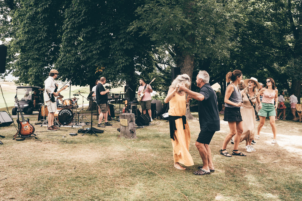 A Group of people dance on a hot day in Millbrook near Arrowtown Queenstown New Zealand. They are dancing to the excellent music of Bourbon Sour, Best Southern Rock Band
