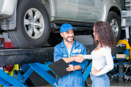 Garagist en cliente in gesprek na een ingreep aan een wagen in een autogarage