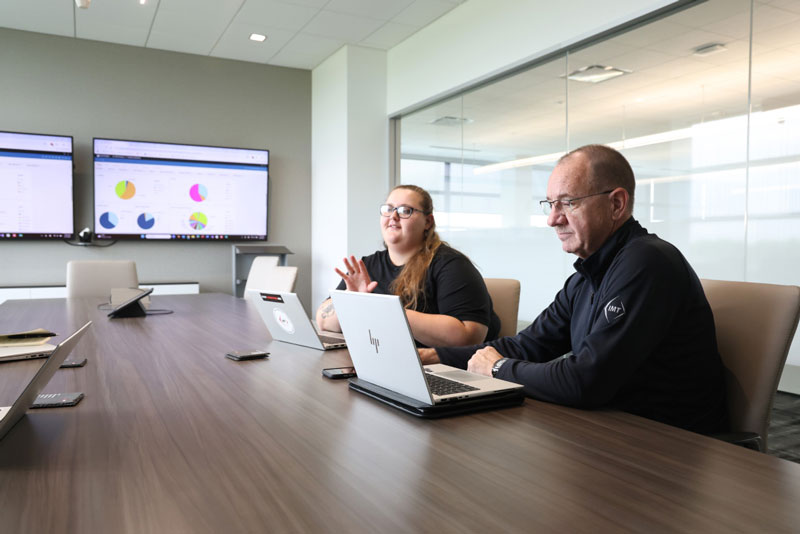 IMT employees collaborating on laptop