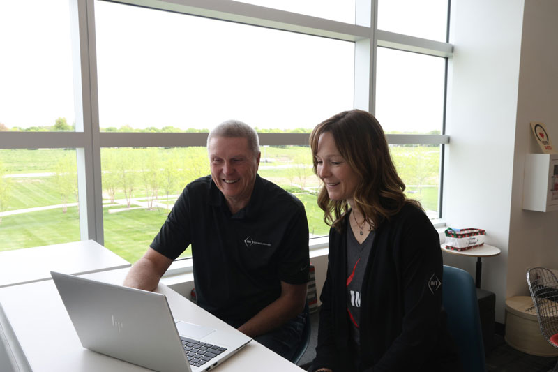 IMT employees collaborating on laptop