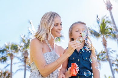 A parent and child blow bubbles at The Breakers 