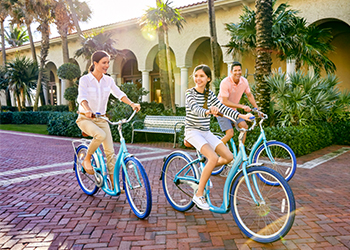 A family of three enjoys a bike ride at The Breakers