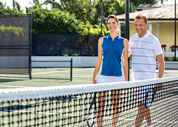 A couple on the tennis court at The Breakers Palm Beach