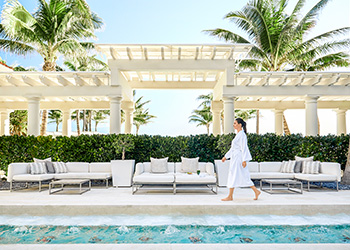 A woman walking in the courtyard at at The Breakers Palm Beach Spa