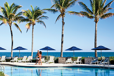 A couple walk along the side of The Breakers Active Pool