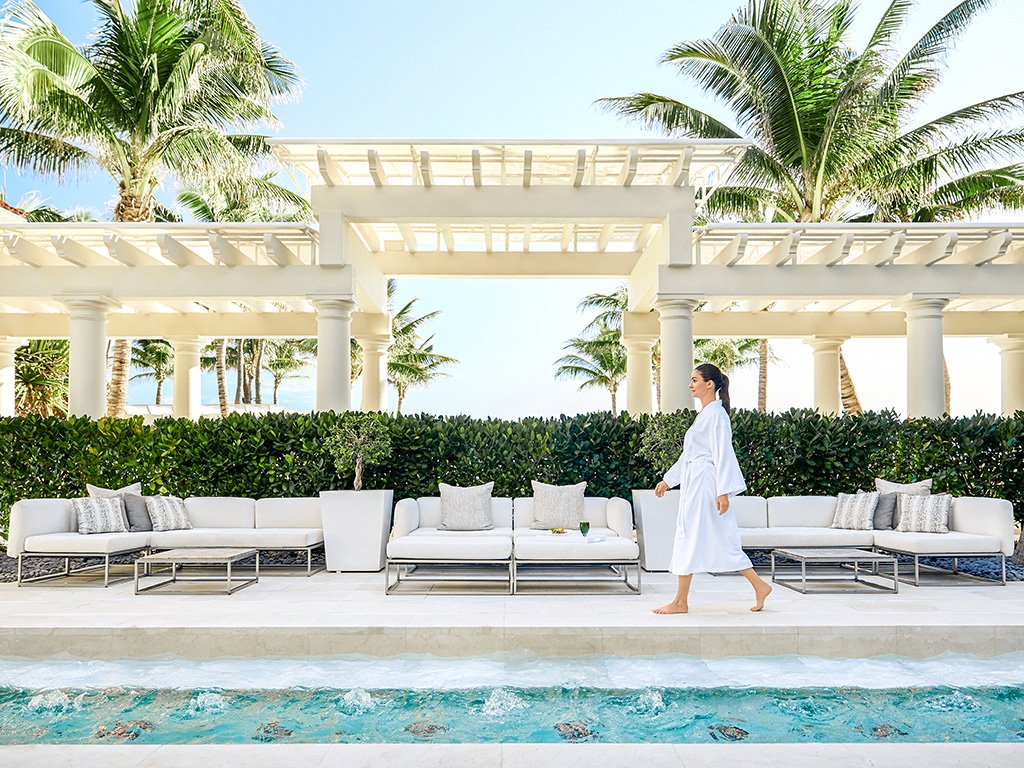 A woman walking in the courtyard at at The Breakers Palm Beach Spa