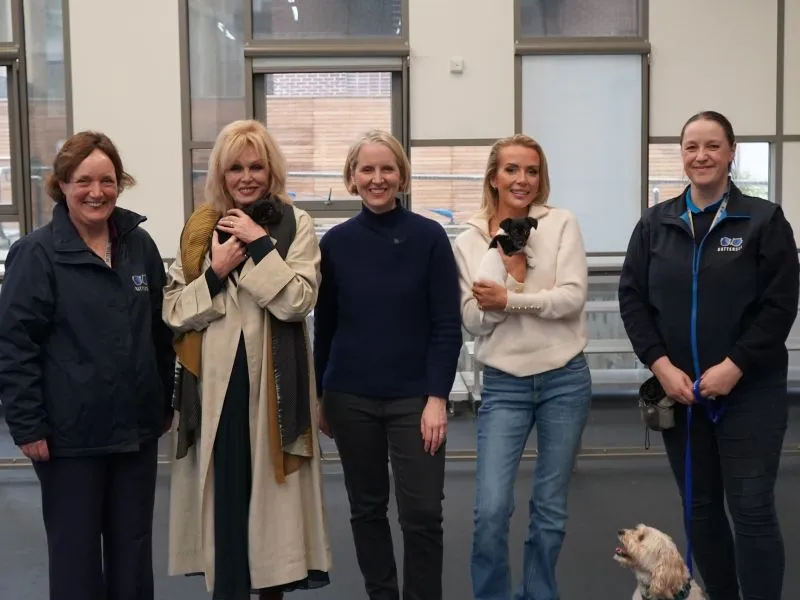 Dame Joanna Lumley smiles for the camera as she cuddles a puppy flanked by senior Battersea figures Lucy Hastings and Rebecca MacIver, DEFRA Secretary Emma Reynolds MP and TV personality Faye Winter.