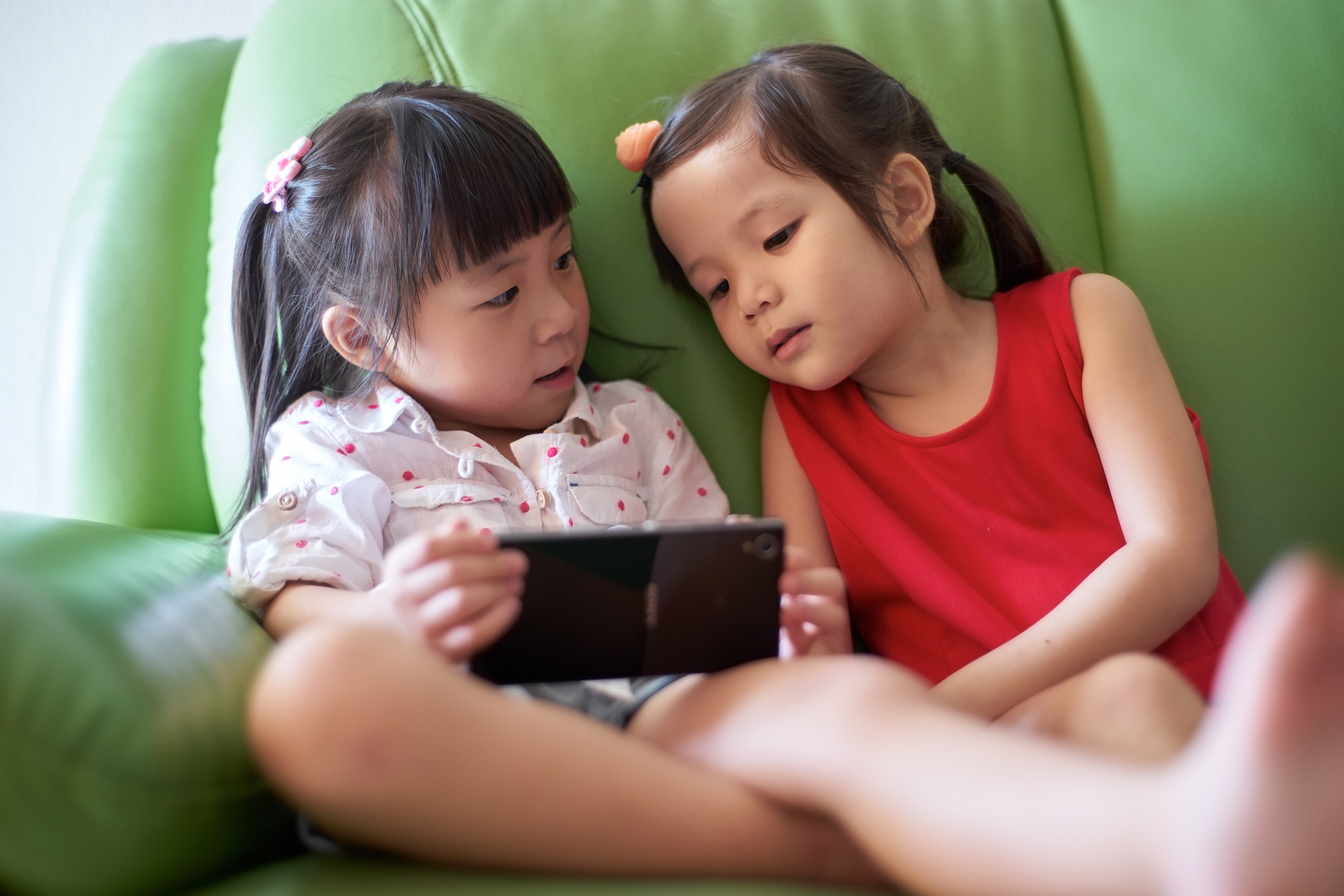 graphicstock-two-asian-girls-playing-with-smart-phone_rdIQTswgox-1