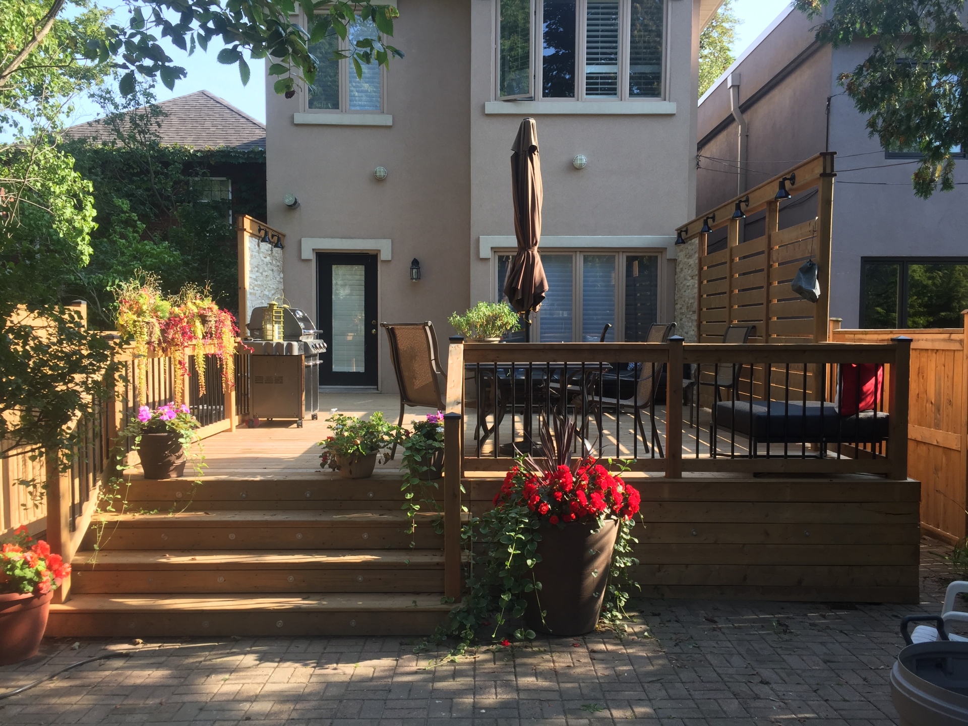 Pressure treated deck with black balusters, lighting, privacy screen and stone accent wall