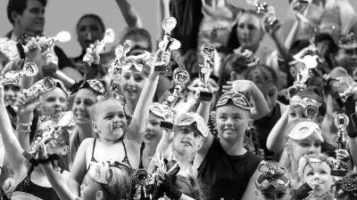 Dance students on stage with trophies