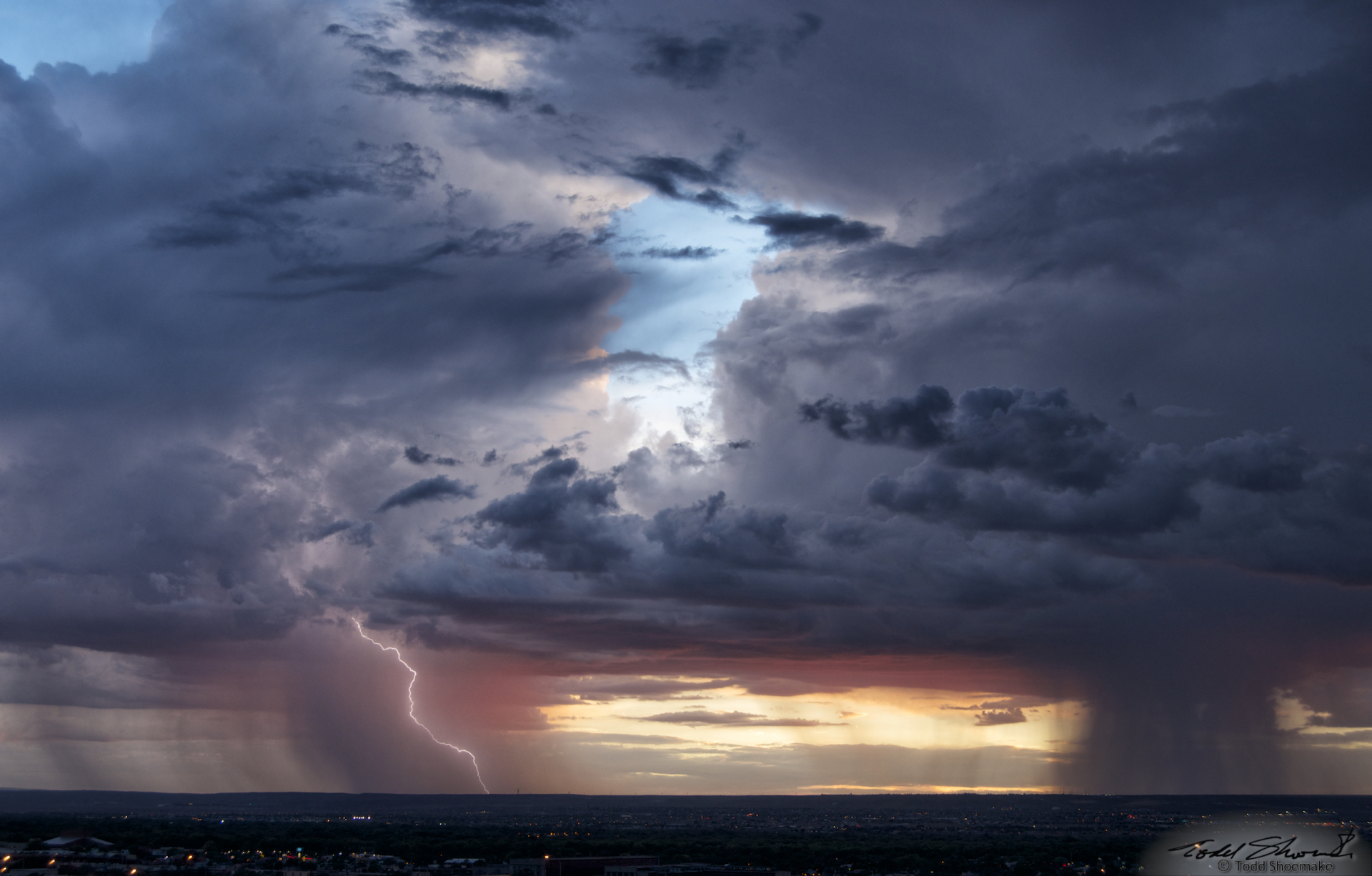 Two storms viewed on the distant horizon with lightning occurring near sunset.