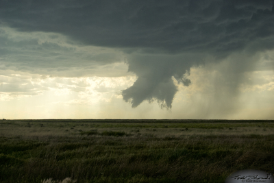 A funnel cloud and fragments of scud clouds develop with a parent supercell over southeastern Colorado.