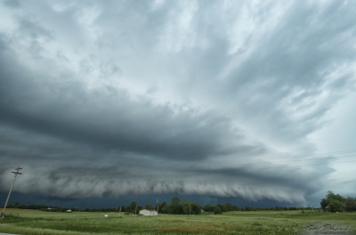 A pronounced shelf cloud develops as a supercell begins to turn outflow dominant, racing over central Oklahoma.