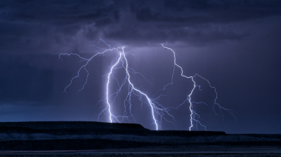 Lightning strikes just beyond a distant mesa in central New Mexico.