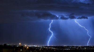 Dual cloud-to-ground lightning strikes are seen from the foothills in eastern Albuquerque.