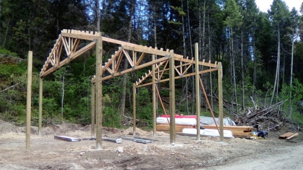 Pressure treated poles are set and trusses going up