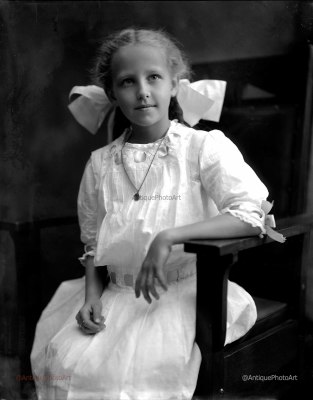 Girl in white dress with large bow in her hair