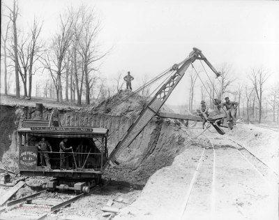 Men Sitting in the Bucket of a Steam Shovel