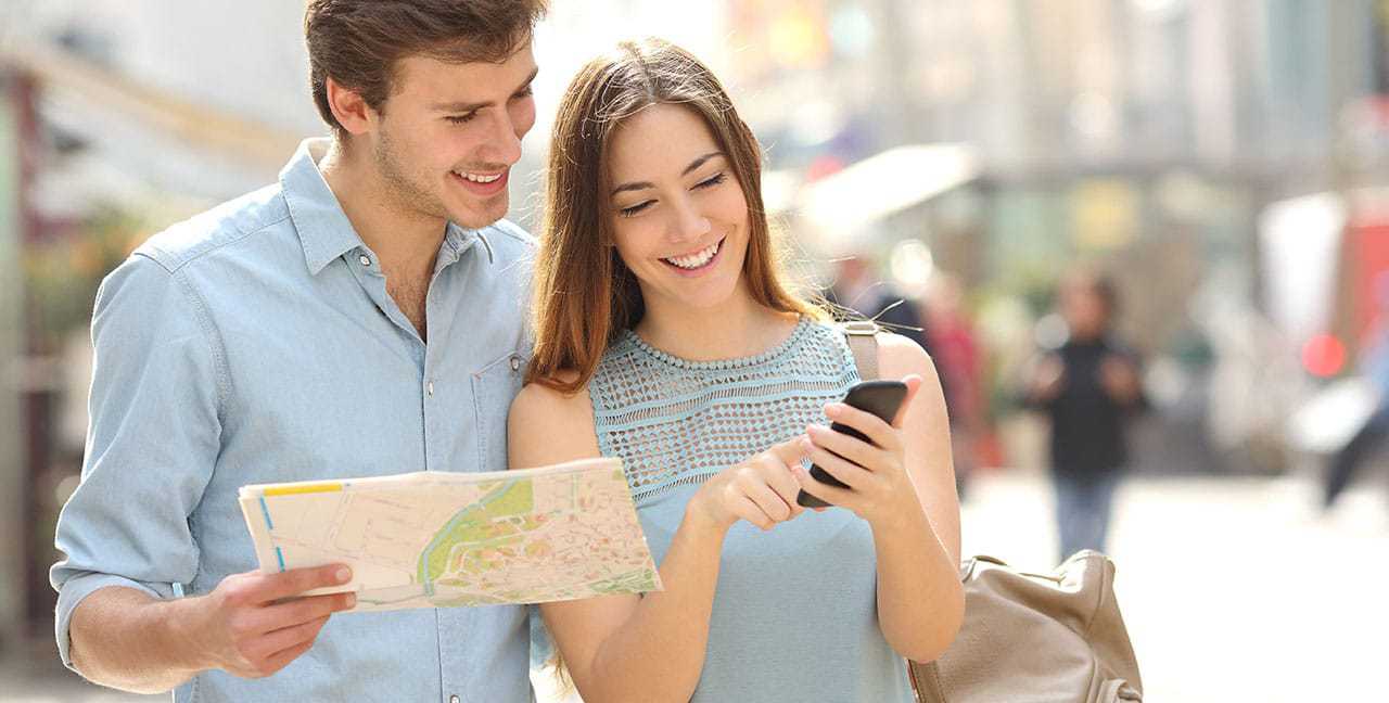 Two tourists with a map and a smartphone