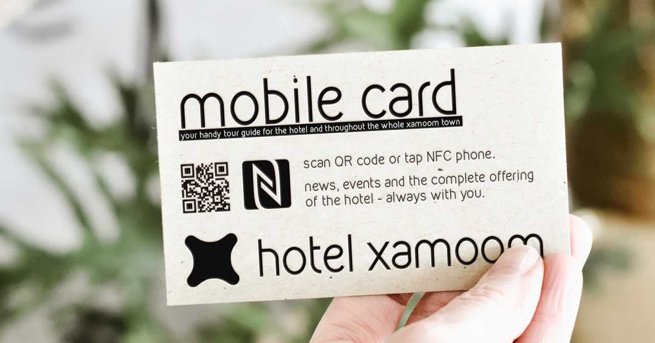 A gutest honlding up a mobile card from the hotel.