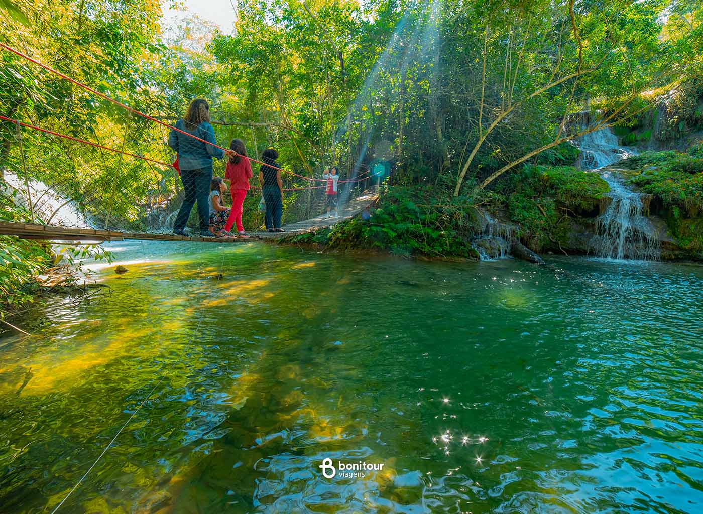 Pessoas passando em ponte por cima do Rio do Peixe em Bonito