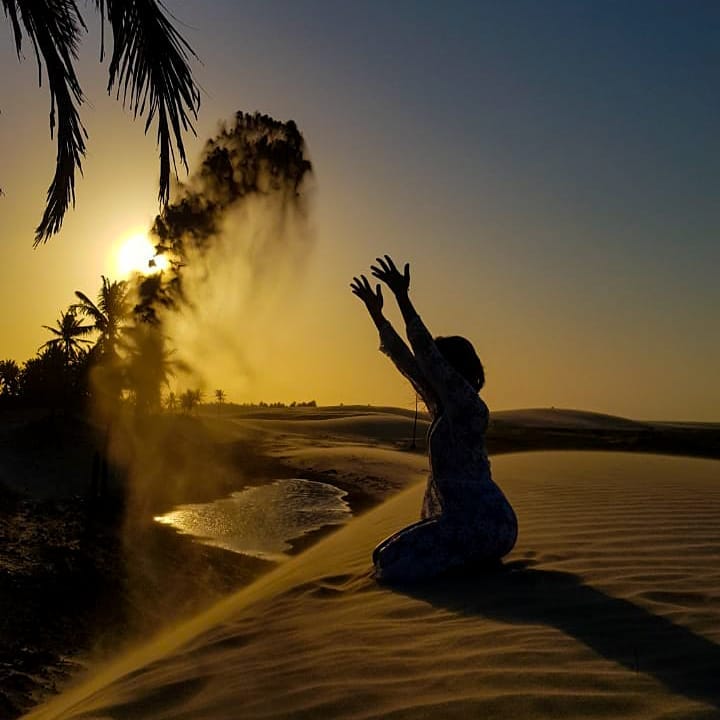 Turista brincando com areia nas dunas douradas de Barrinha