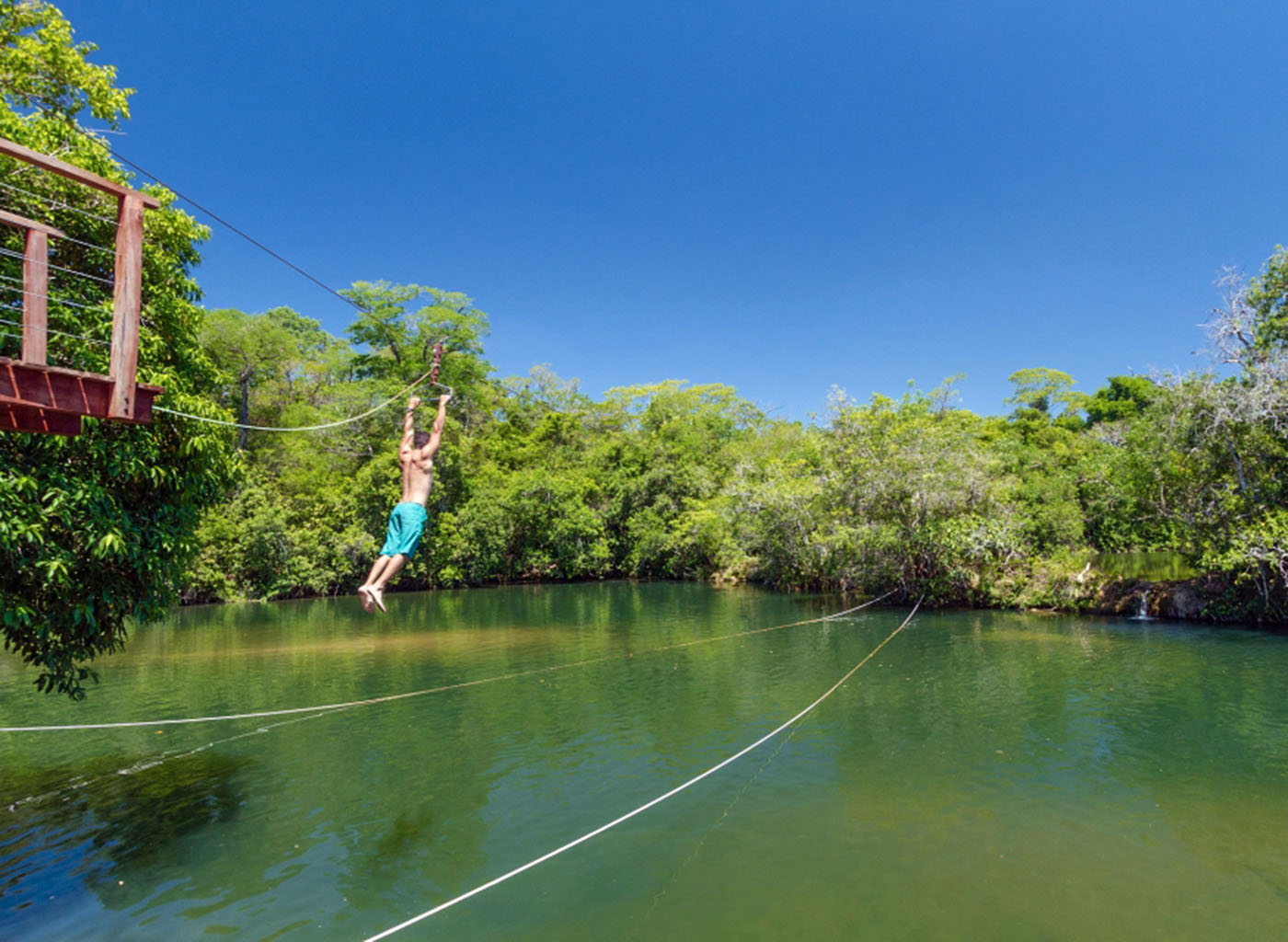 Pessoa descendo de tirolesa no balneário Cachoeiras Serra da Bodoquena
