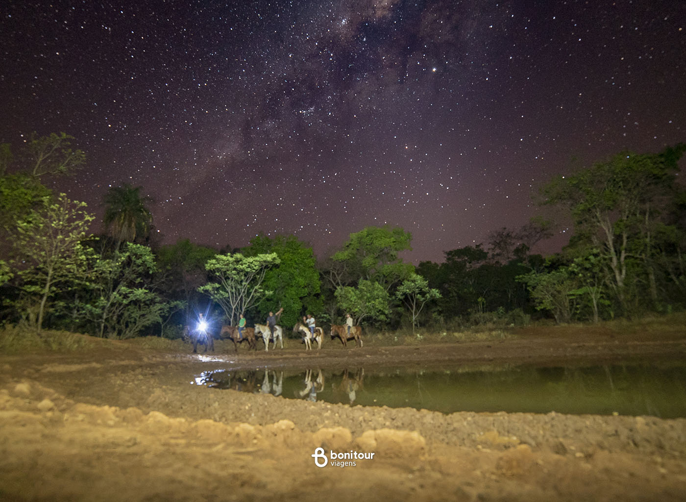 Pessoas cavalgando pela noite estrelada de Bonito