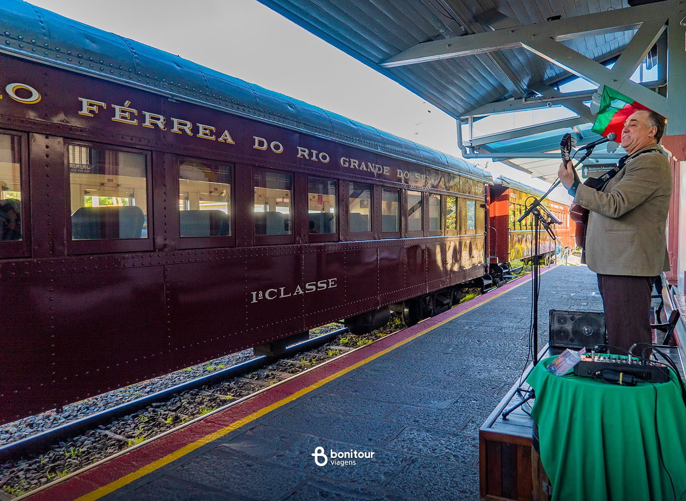 Pessoa cantando e tocando violão em estação de trem