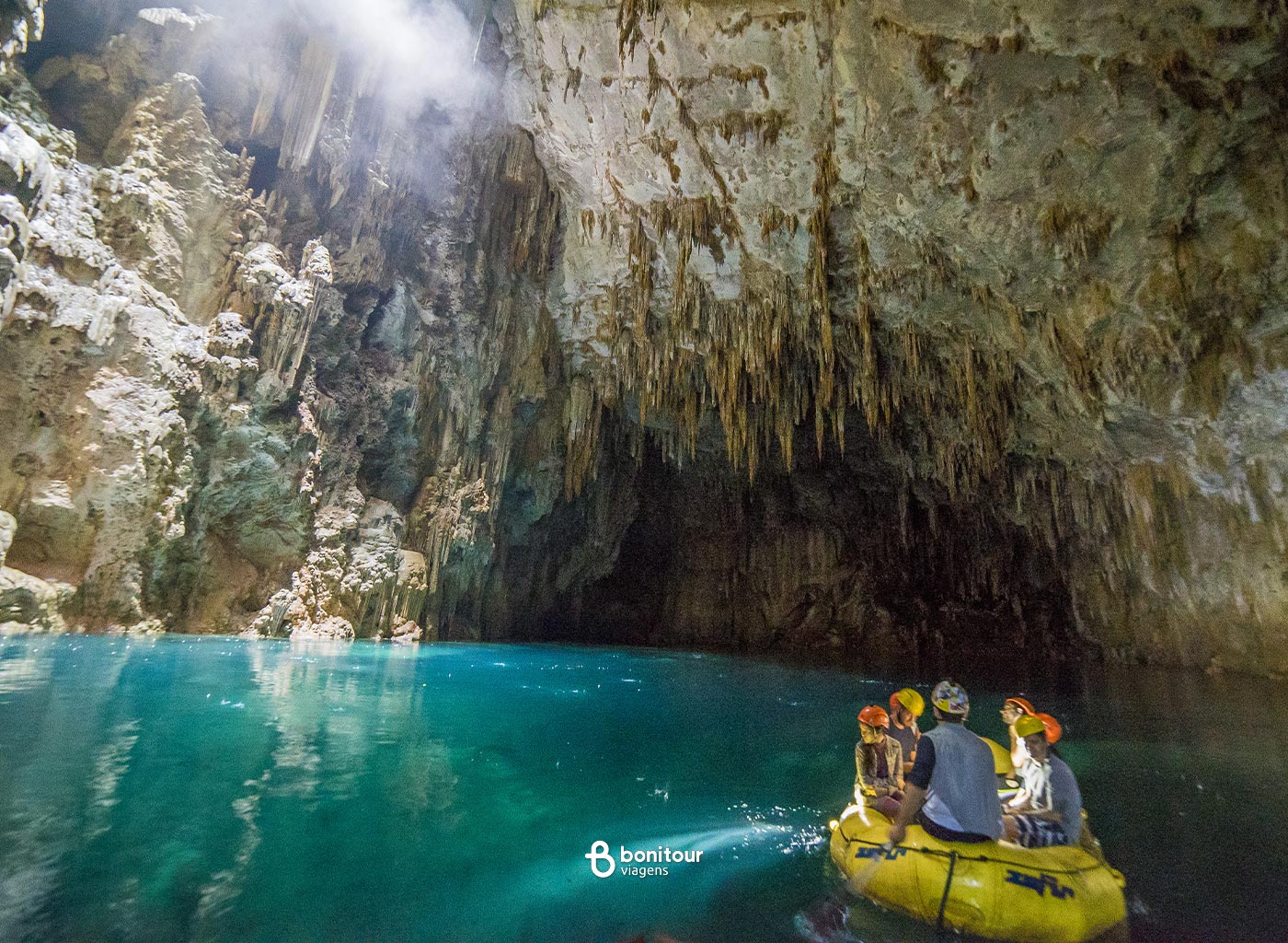 Pessoas navegando de Bote nas águas dentro do Abismo Anhumas