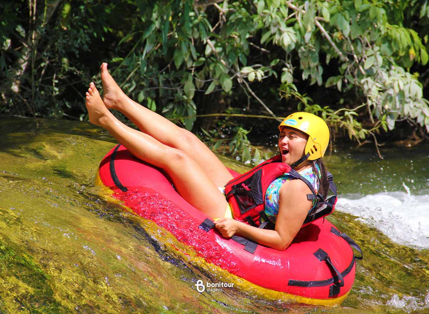 Pessoa de boia descendo pelas águas do rio Formoso em meio a natureza