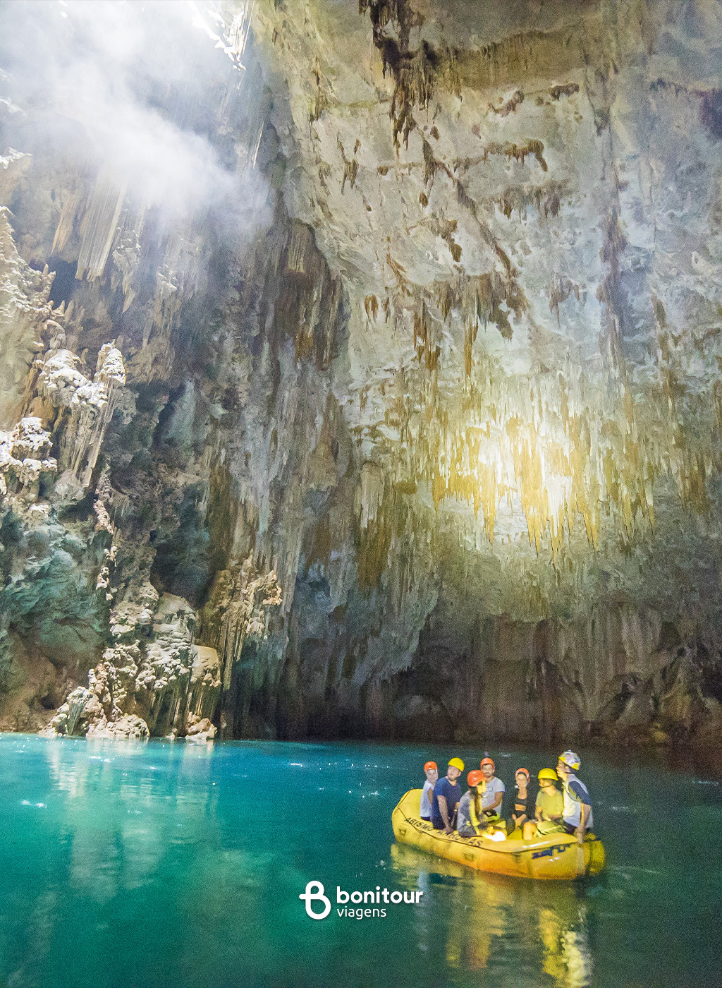 Pessoas de bote dentro do Abismo Anhumas com águas cristalinas e formações rochosas