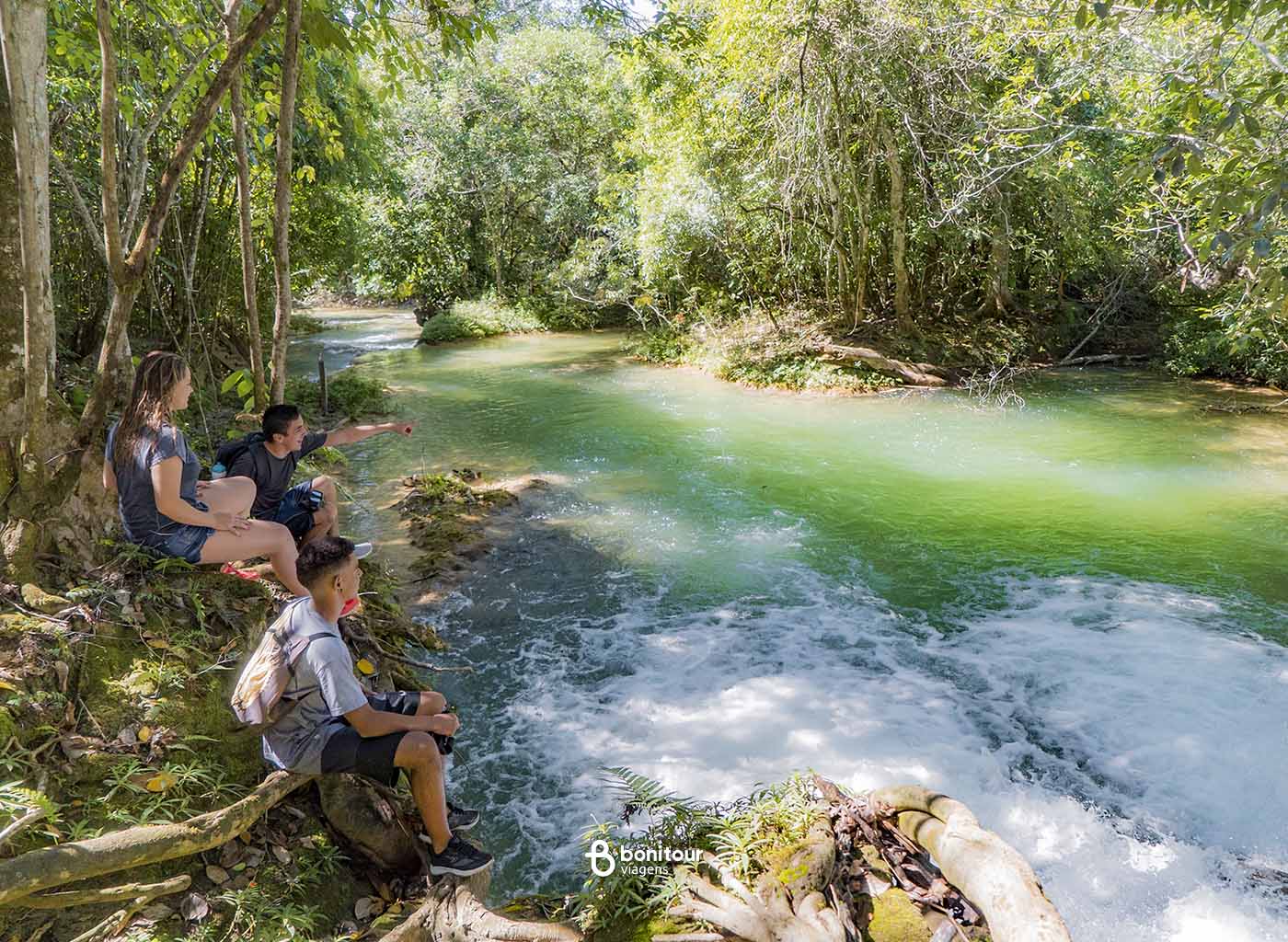 Três turistas observando uma das quedas de cachoeiras da Serra da Bodoquena