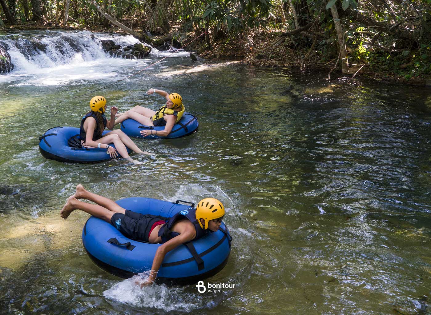 Pessoas se divertindo de boia cross em meio a natureza