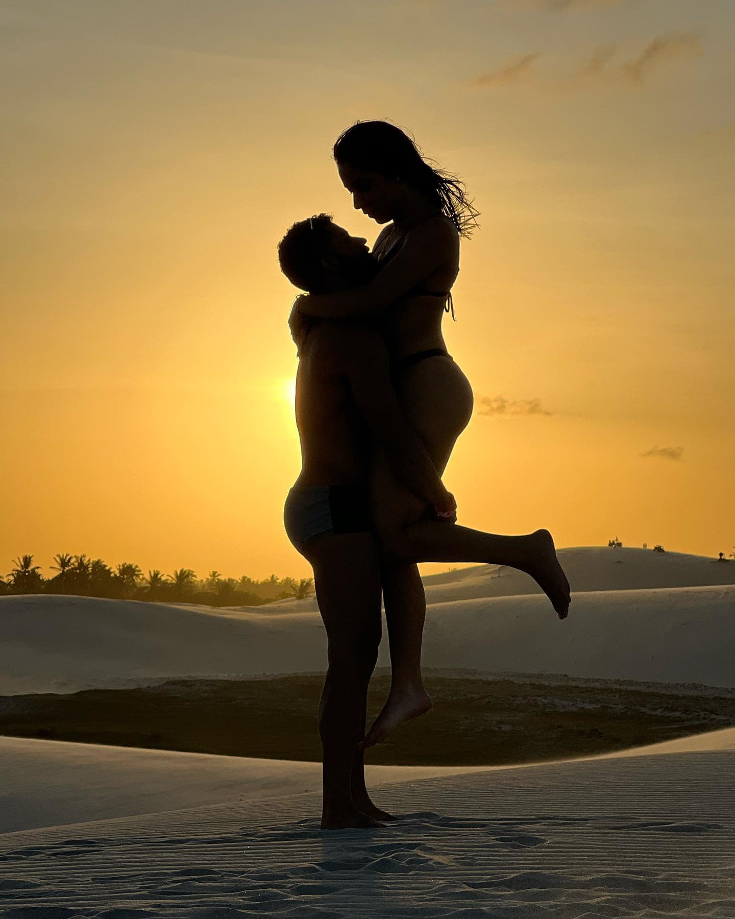 Casal em momento romântico ao pôr do sol nas dunas de Jericoacoara