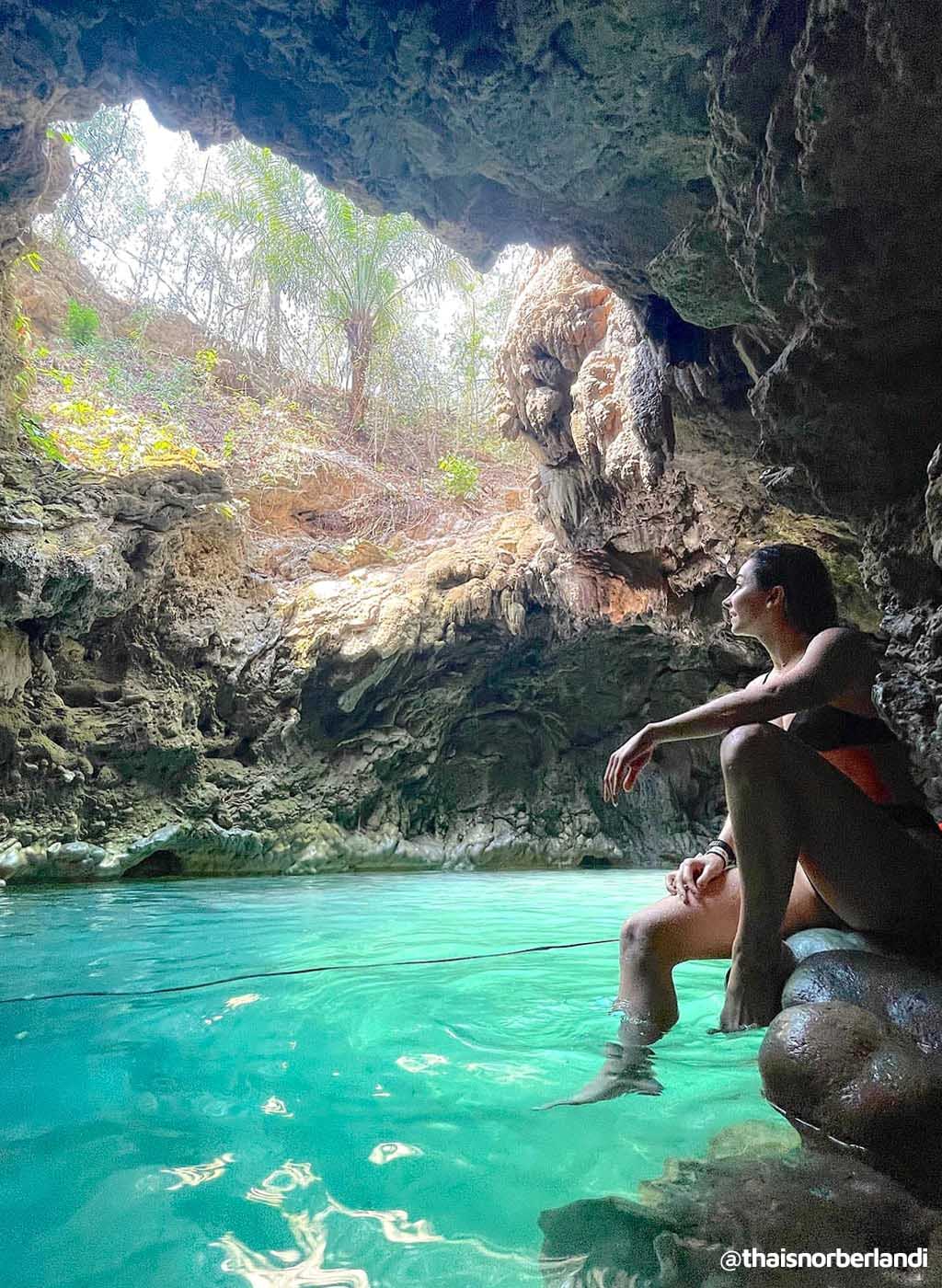 Pessoa aproveitando águas cristalinas de dentro do Buraco do Macaco