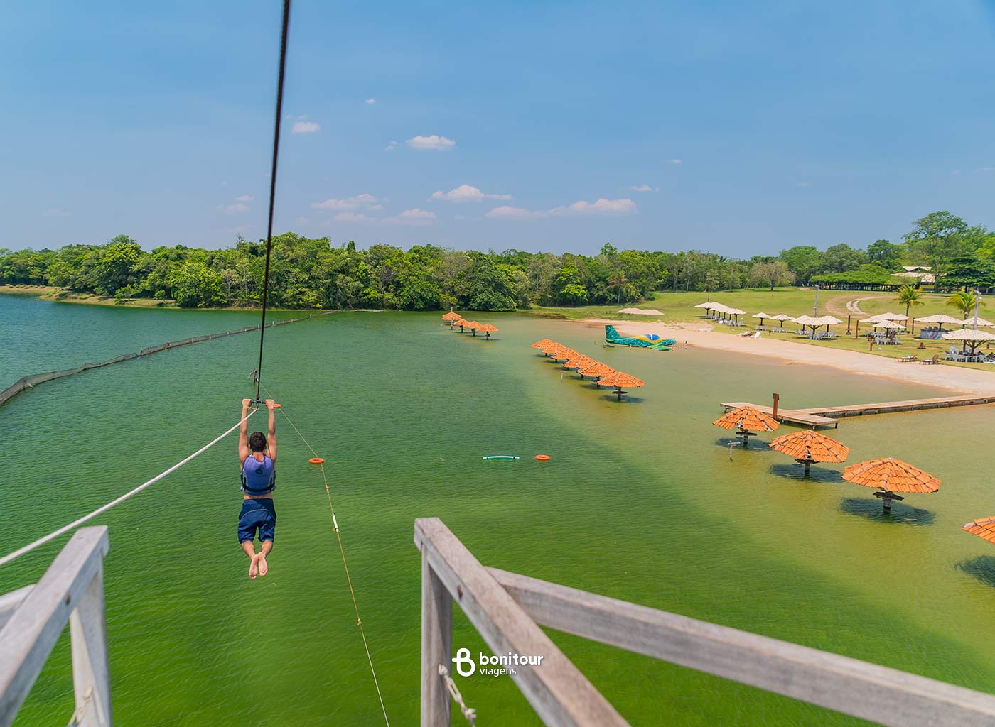 Pessoa descendo de tirolesa em cima da praia da Figueira