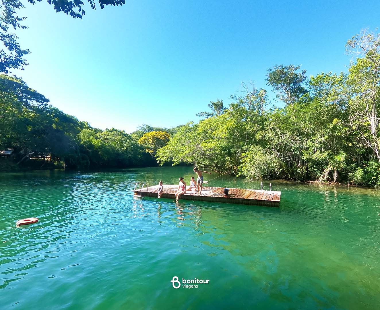 Deck de madeira a beira de águas cristalinas e cachoeira