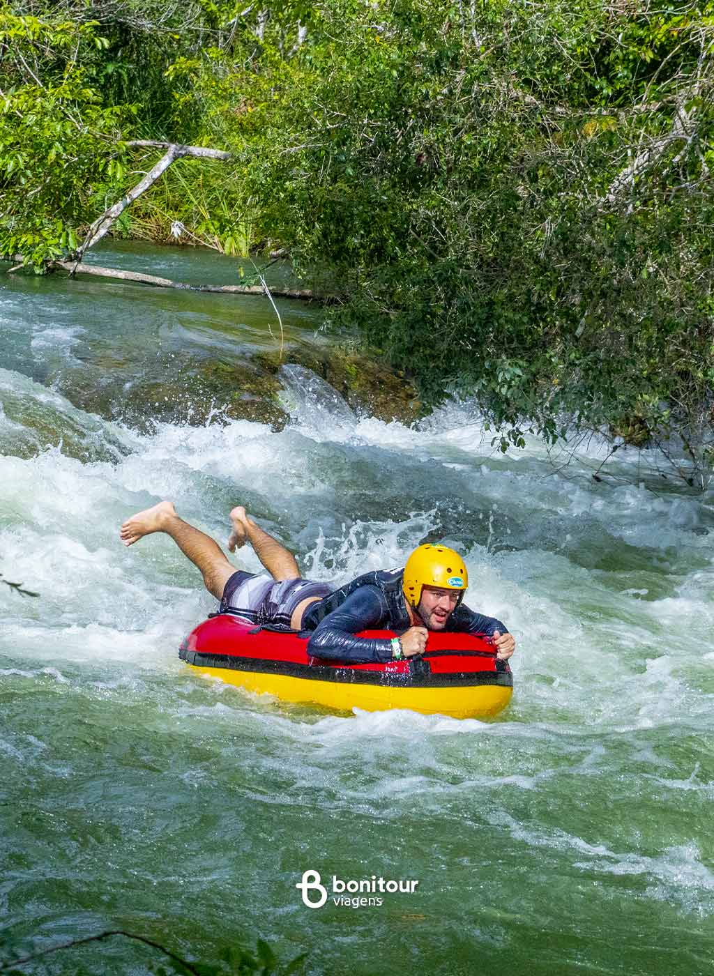 Pessoa de boia descendo pelas águas do rio Formoso em meio a natureza